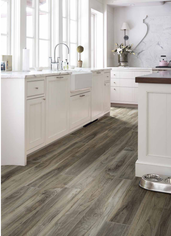 Laminate Floor with a wood-look in white kitchen featuring island, counter tops, white tile backsplash